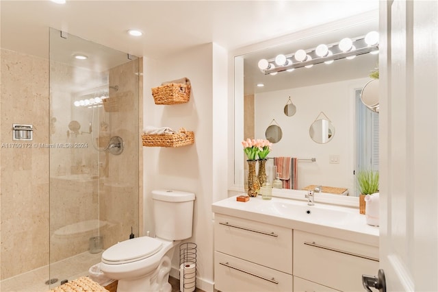 bathroom featuring vanity, toilet, and a shower with shower door