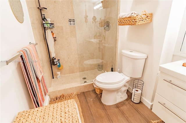 bathroom with vanity, toilet, and a tile shower