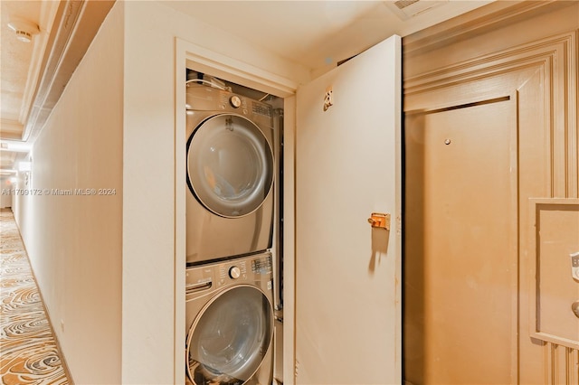 laundry area featuring stacked washer / drying machine