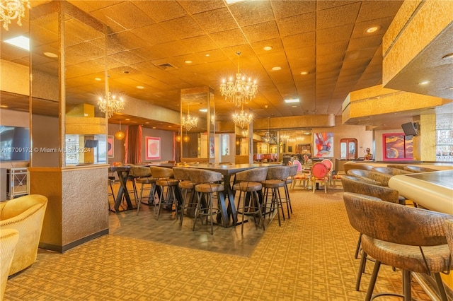 dining space featuring bar area and an inviting chandelier