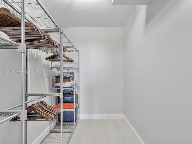 walk in closet with light wood-type flooring