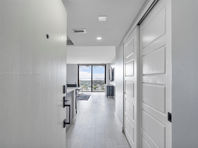 corridor featuring expansive windows and light wood-type flooring