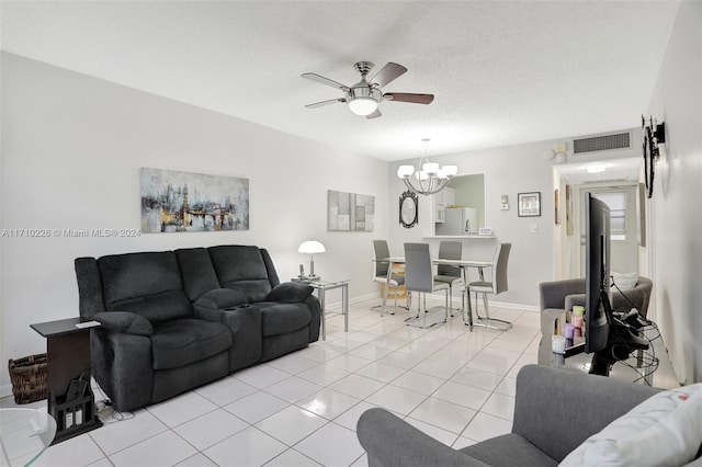 tiled living room with ceiling fan with notable chandelier and a textured ceiling