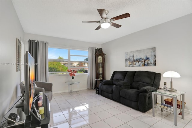 living room with a textured ceiling, ceiling fan, and light tile patterned flooring