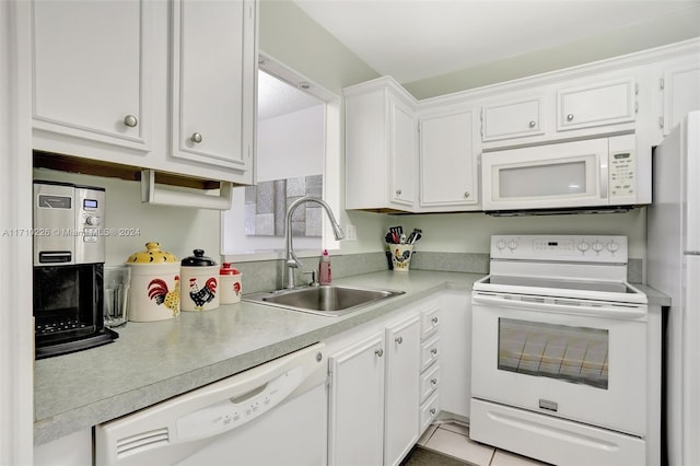 kitchen featuring white cabinets, light tile patterned flooring, white appliances, and sink