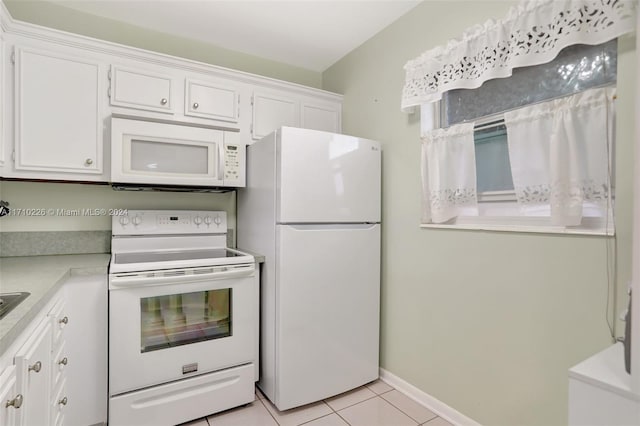 kitchen with white cabinetry, white appliances, and light tile patterned floors