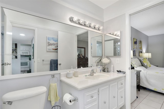 bathroom with tile patterned flooring, vanity, and toilet