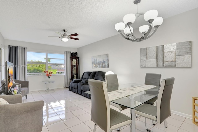 tiled dining space with ceiling fan with notable chandelier and a textured ceiling