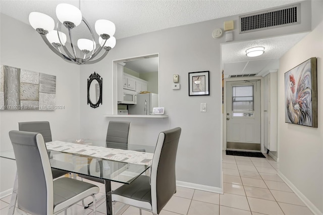 tiled dining area with a textured ceiling and an inviting chandelier