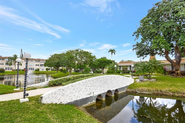 view of property's community featuring a lawn and a water view