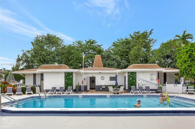 back of property with a patio area and a community pool