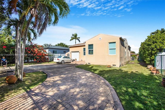 view of front of house with a garage and a front lawn