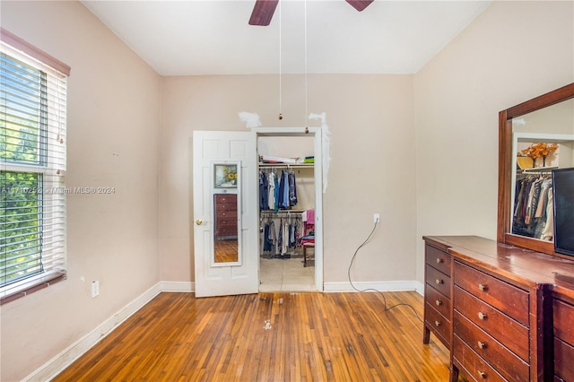 bedroom with ceiling fan, wood-type flooring, and a closet