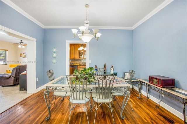 dining area featuring crown molding, wood-type flooring, and ceiling fan with notable chandelier