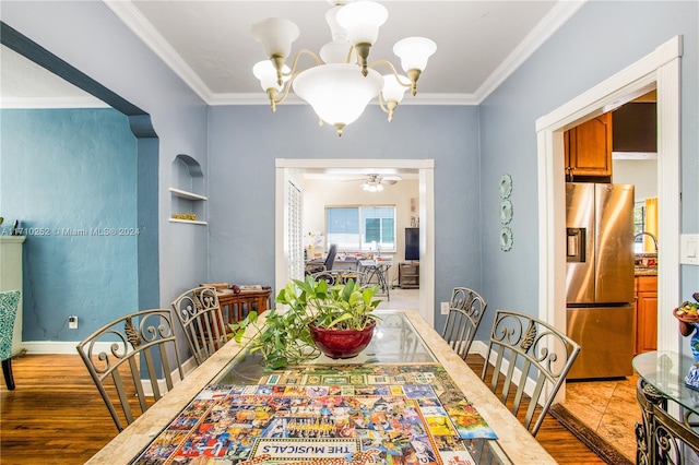 dining area with ceiling fan with notable chandelier, light hardwood / wood-style flooring, and crown molding