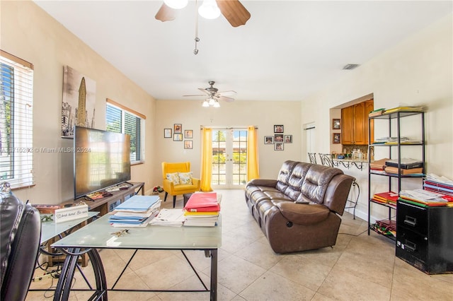 tiled living room with ceiling fan and french doors