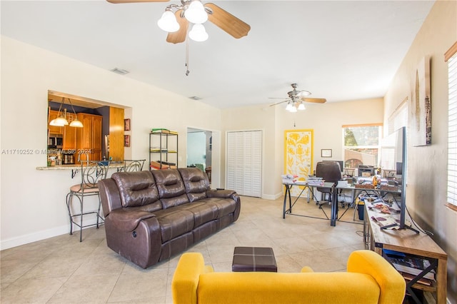 tiled living room with ceiling fan with notable chandelier