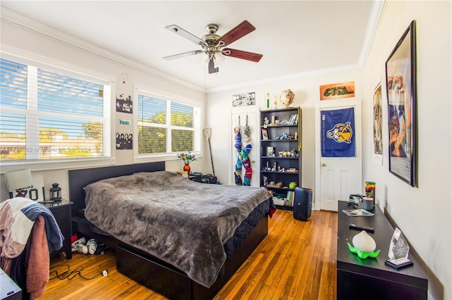 bedroom featuring hardwood / wood-style flooring, ceiling fan, and crown molding