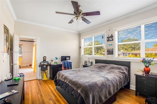 bedroom featuring wood-type flooring, ceiling fan, and crown molding