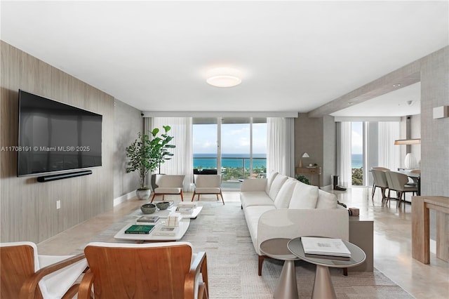 living room with a water view, finished concrete flooring, and expansive windows