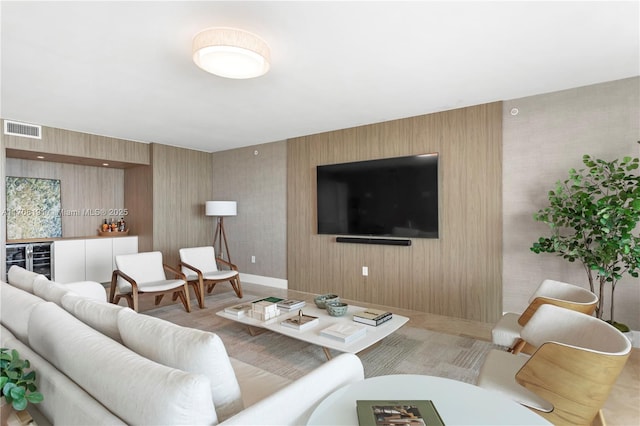 living area featuring wine cooler, baseboards, visible vents, and a bar