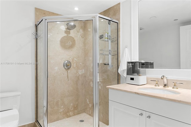 bathroom featuring a stall shower, vanity, and toilet