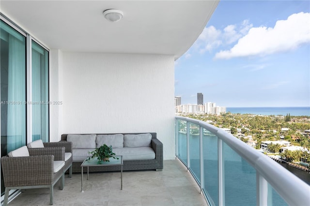 balcony with an outdoor living space, a water view, and a city view