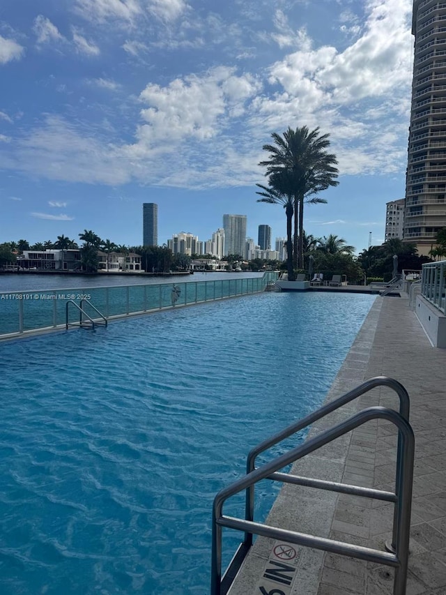 view of swimming pool with a water view and a view of city