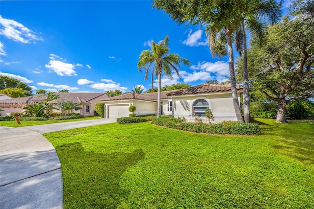 mediterranean / spanish-style house with a garage and a front lawn