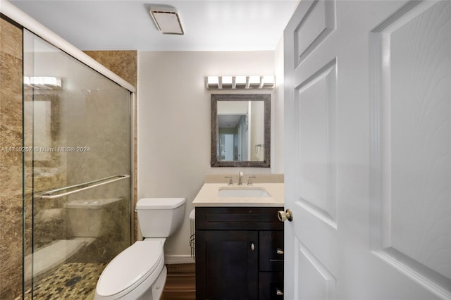 bathroom with hardwood / wood-style floors, vanity, toilet, and a shower with door