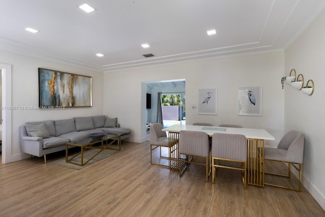 dining area with ornamental molding and light wood-type flooring