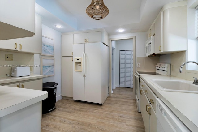 kitchen with sink, white cabinets, light hardwood / wood-style floors, and white appliances