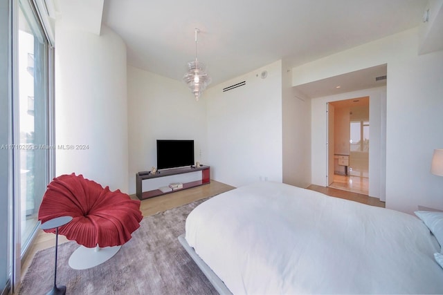 bedroom with wood-type flooring and connected bathroom