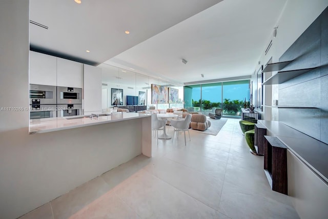 kitchen featuring white cabinets, floor to ceiling windows, and double oven