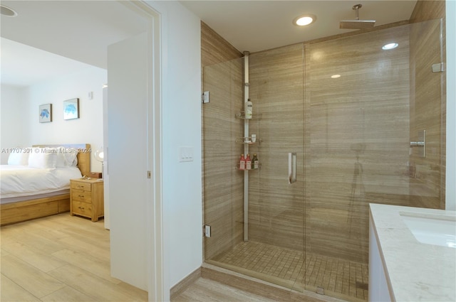 bathroom with vanity, an enclosed shower, and hardwood / wood-style flooring