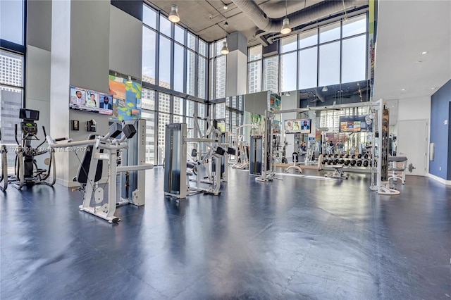 exercise room featuring a towering ceiling