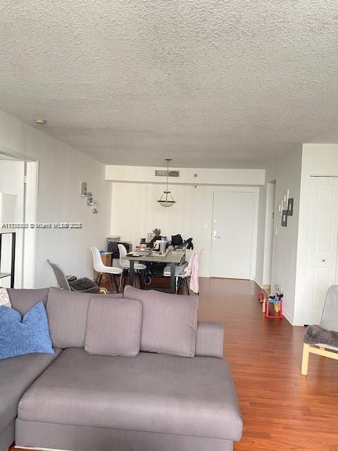 living room with hardwood / wood-style floors and a textured ceiling