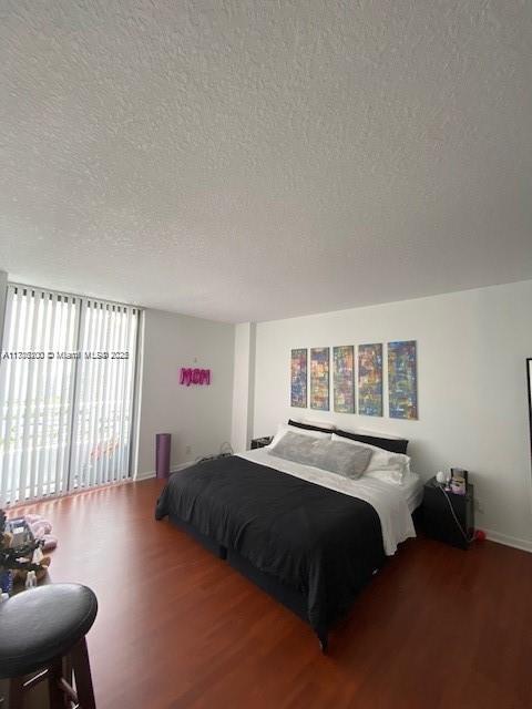 bedroom with wood-type flooring and a textured ceiling