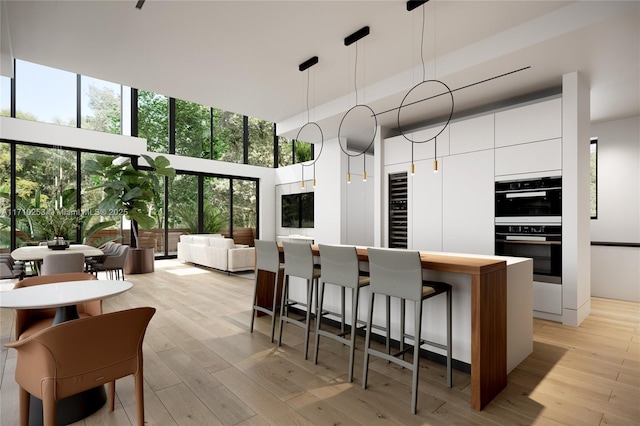 kitchen featuring white cabinetry, double oven, modern cabinets, and light wood-type flooring