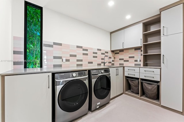 washroom with recessed lighting, cabinet space, independent washer and dryer, and a sink