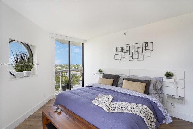 bedroom with dark wood-type flooring and a wall of windows