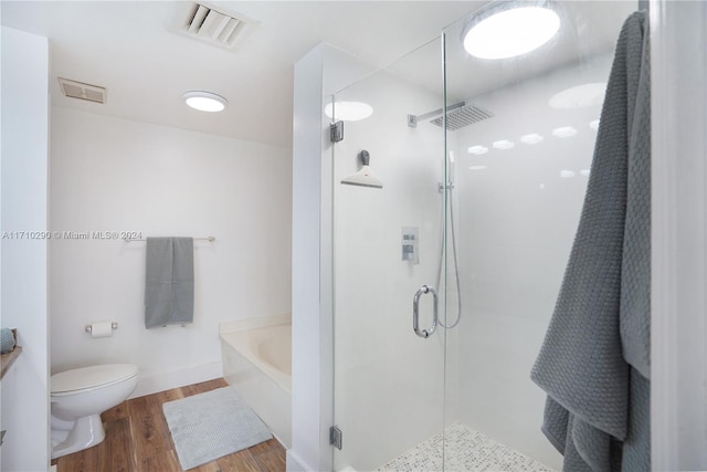 bathroom with hardwood / wood-style floors, toilet, and independent shower and bath