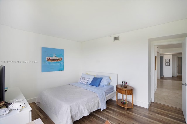 bedroom with dark wood-type flooring