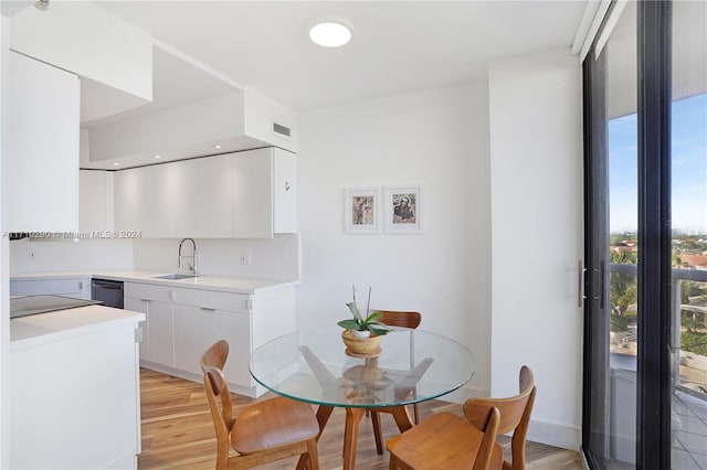 dining space with sink and light wood-type flooring