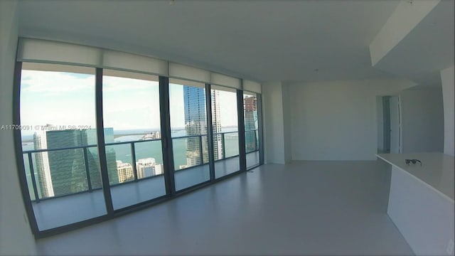 spare room featuring plenty of natural light, a water view, and concrete flooring