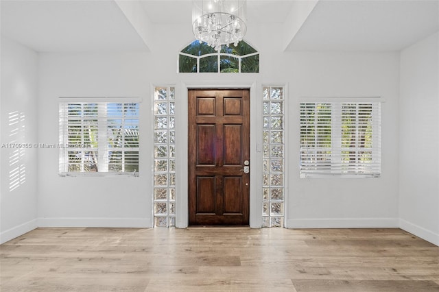 entrance foyer with a chandelier, light hardwood / wood-style floors, and plenty of natural light