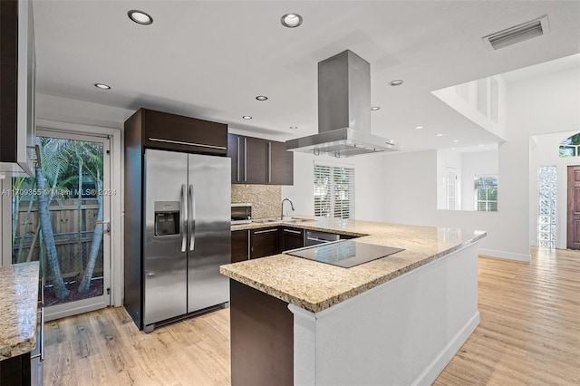 kitchen featuring kitchen peninsula, light wood-type flooring, black electric cooktop, extractor fan, and stainless steel fridge with ice dispenser