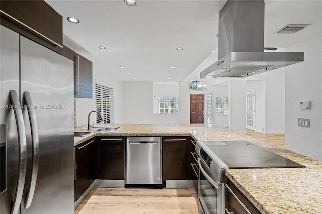 kitchen with wall chimney exhaust hood, sink, stainless steel appliances, and light hardwood / wood-style flooring