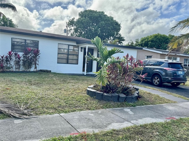 single story home featuring a front lawn