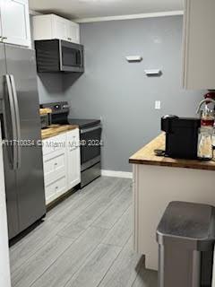 kitchen featuring white cabinets, appliances with stainless steel finishes, and light wood-type flooring